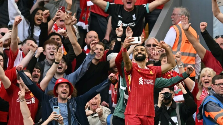 Liverpool forward Mohamed Salah takes a selfie with fans after scoring their fourth goal against Tottenham