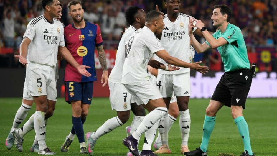Real Madrid players remonstrate with Spanish referee Ricardo De Burgos Bengoetxea