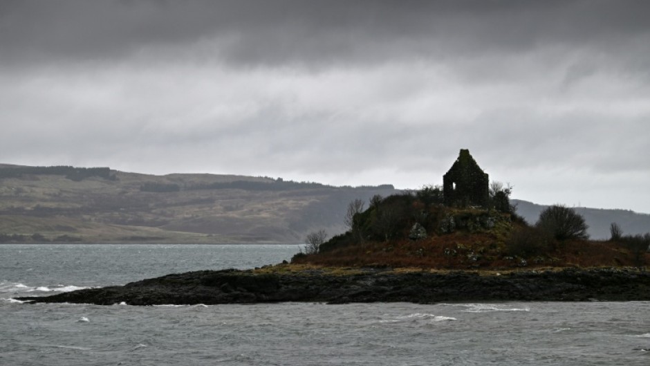 The Isle of Mull, pictured beyond a building in the foreground, across the Sound of Mull