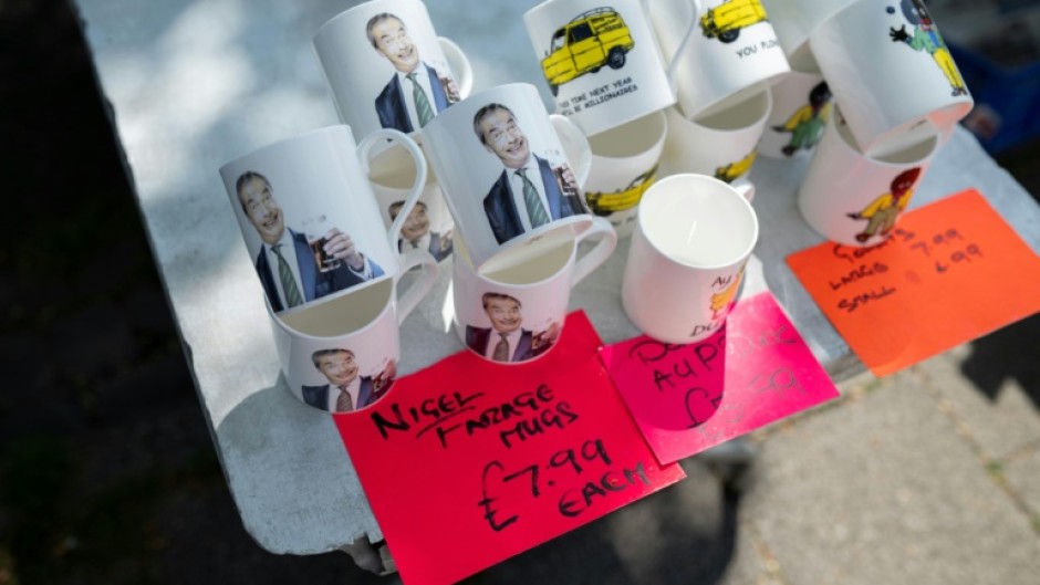 Mugs bearing the image of Reform UK party leader Nigel Farage are displayed on a stall on a street market in Frodsham, near Runcorn, northwest England, where Reform has been pushing hard to oust Labour and win a parliamentary by-election