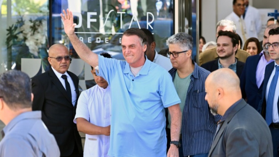 Brazilian former president Jair Bolsonaro waves to supporters as he leaves hospital on May 4, 2025, three weeks after undergoing surgery to treat an intestinal obstruction