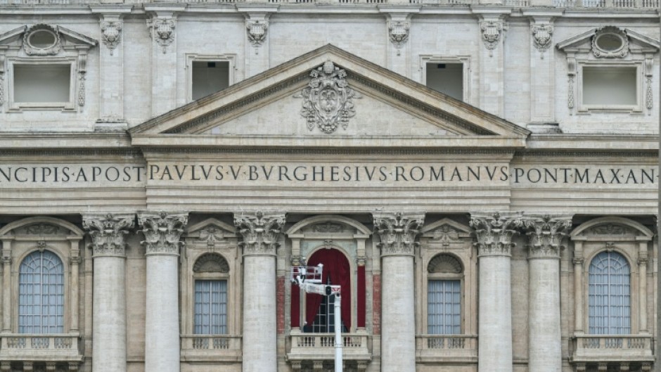 A worker prepares the main central balcony of St Peter's basilica