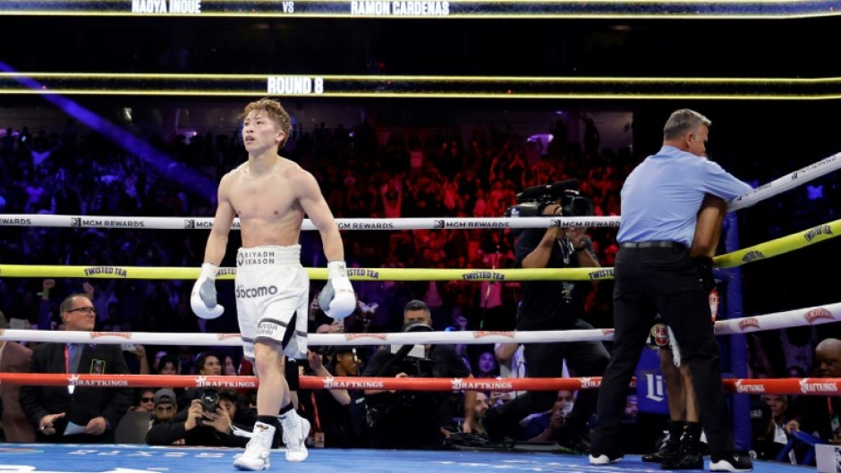 Undisputed super bantamweight champion Naoya Inoue of Japan, at left, walks away as referee Thomas Taylor stops the fight against American Ramon Cardenas in the eighth round