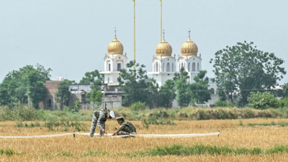 Indian soldiers inspect the debris of a missile in a field on the outskirts of Amritsar