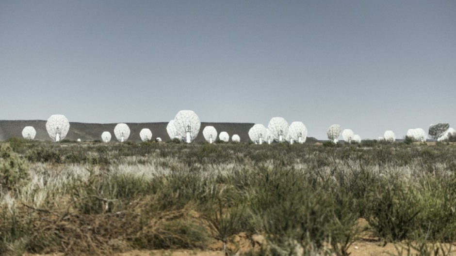 The MeerKAT radio telescope is made up of 64 giant white dishes that stand in a semi-desert region in South Africa