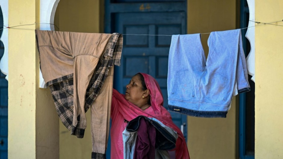 A displaced woman hangs clothes to dry at a Sikh temple in Jammu, a key city in Indian-administered Kashmir