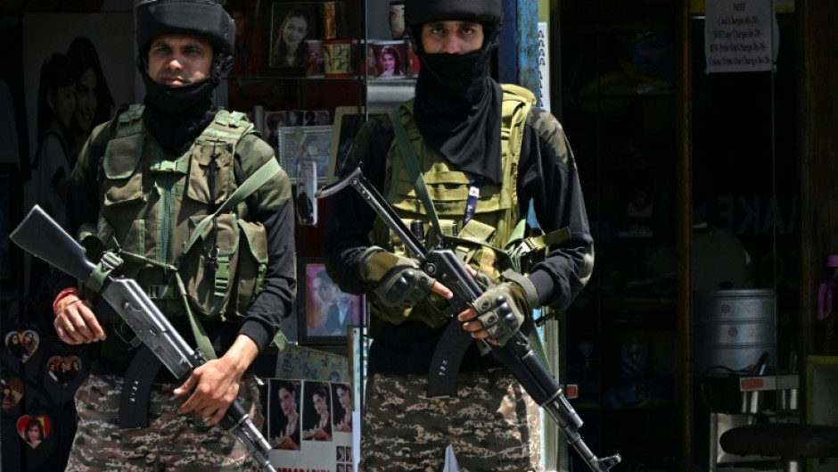 Indian paramilitary troops stand guard on a street in Srinagar in Indian-administered Kashmir