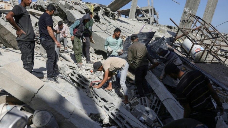 Palestinians sift through the rubble after a strike on northern Gaza's Jabalia