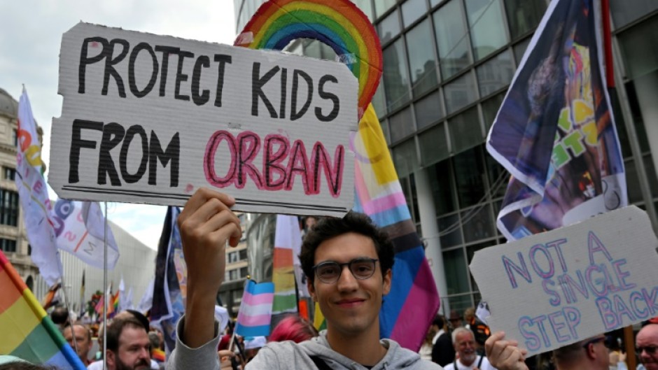 A protester holds a sign reading 'Protect the children from Orban' during a demonstration in Brussels, May 17, 2025.