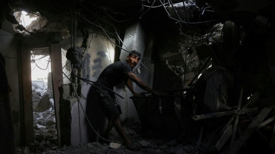 A Palestinian man searches the rubble of a house hit in Israeli strikes on the northern Gaza Strip