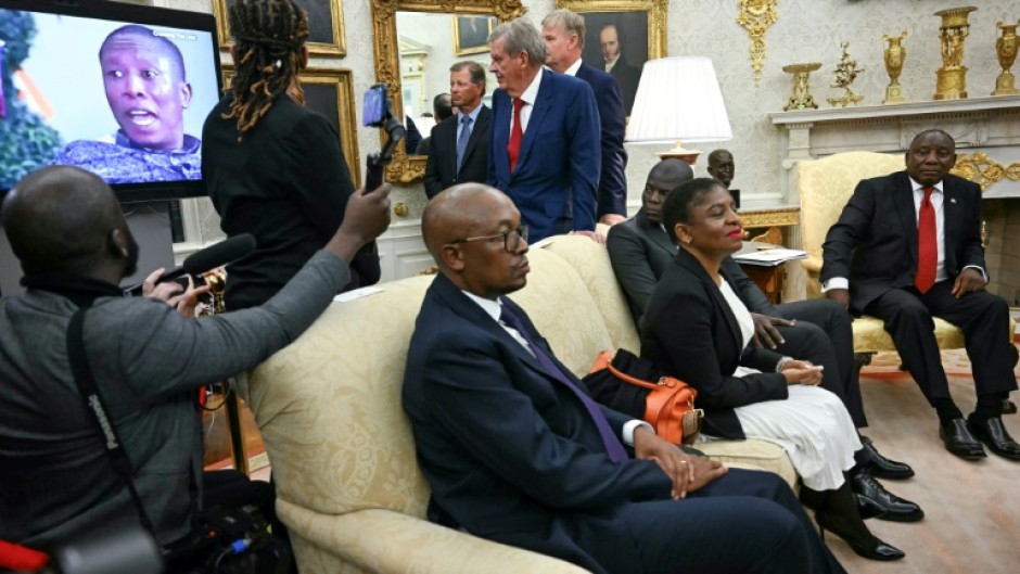 A video is played as South African President Cyril Ramaphosa (R) looks on during a meeting with US President Donald Trump in the Oval Office of the White House in Washington, DC, on May 21, 2025. South African President Cyril Ramaphosa meets Donald Trump on Wednesday amid tensions over Washington's resettlement of white Afrikaners that the US president claims are the victims of "genocide."