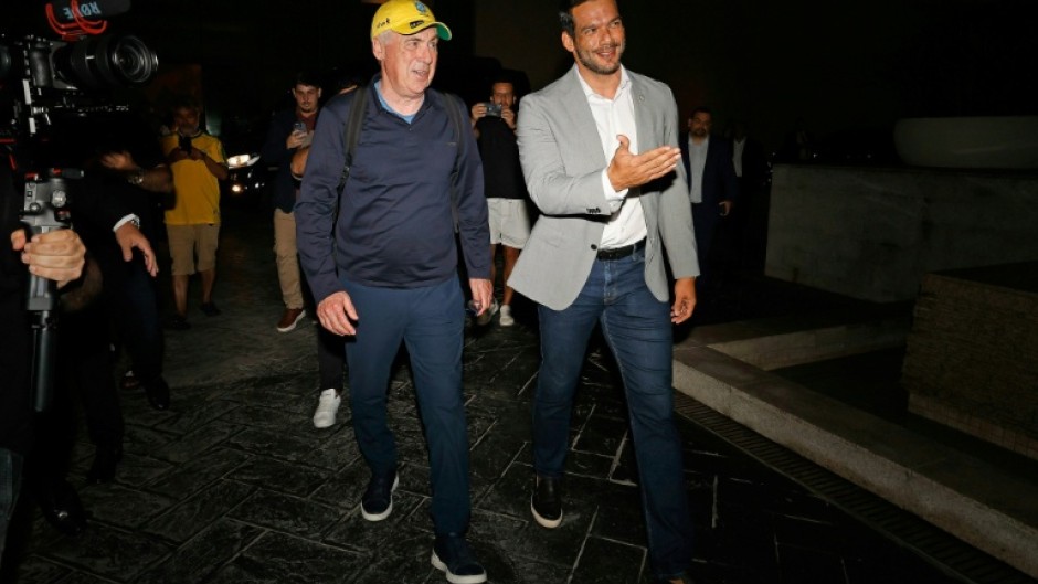 This handout picture released by the Brazilian Football Confederation (CBF) shows the new Brazilian football team head coach Italian Carlo Ancelotti (L) talking with CBF president Samir Xaud as he arrives in Rio to take up his post
