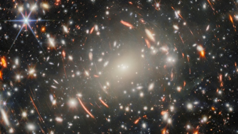 The new image uses a massive galaxy cluster as a magnifying glass to spy on ancient galaxies in the distance universe