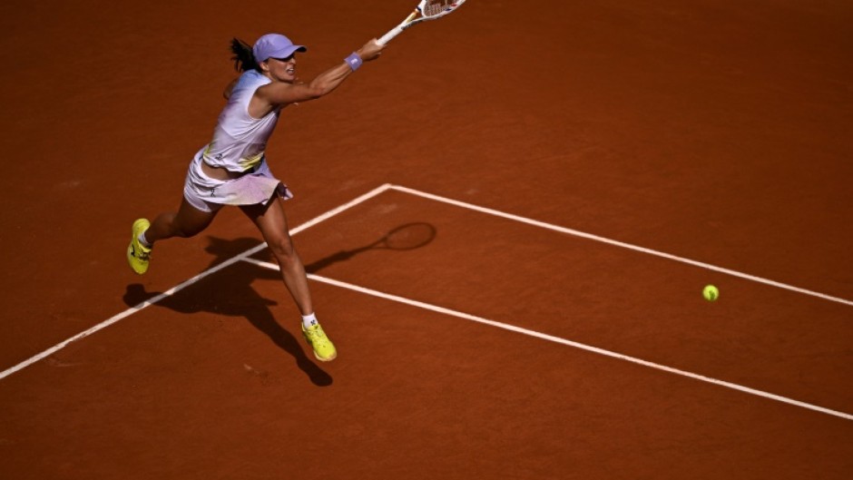 Poland's Iga Swiatek swept past Britain's Emma Raducanu in the second round to keep her bid for a fourth straight French Open title on track