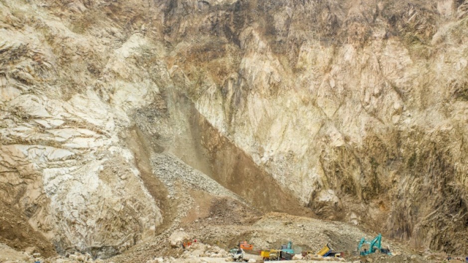Rescuers use heavy equipment to search for people buried by a rockfall at the quarry in Cirebon, Indonesia