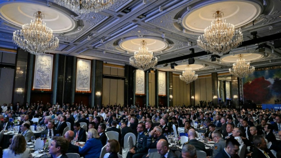 Attendees watch France's President Emmanuel Macron's address at the Shangri-La Dialogue Summit in Singapore