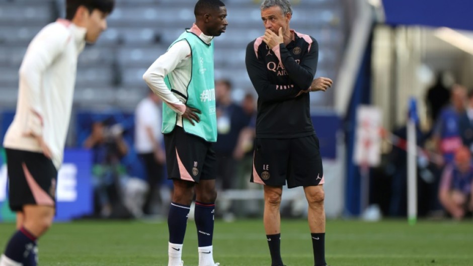 Paris Saint-Germain coach Luis Enrique (R) speaks to Ousmane Dembele on the pitch at Munich's Allianz Arena on Friday