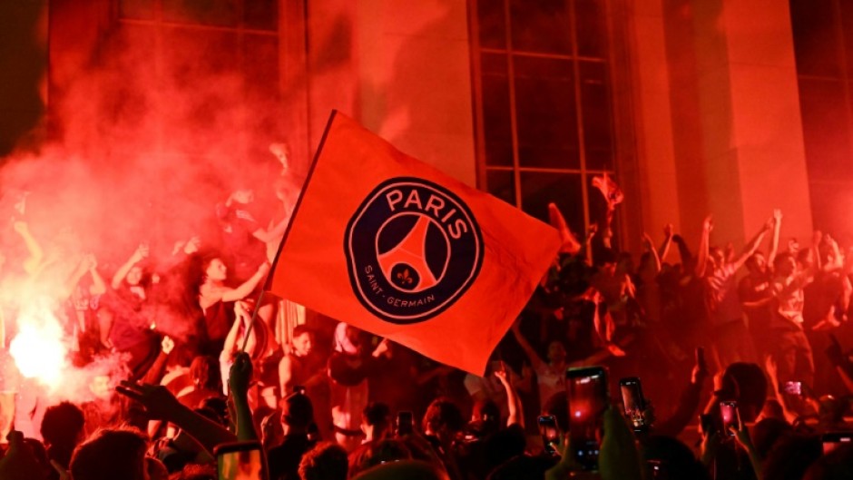 Jubilant Paris Saint-Germain supporters set off flares on Place Trocadero in front of the Eiffel Tower