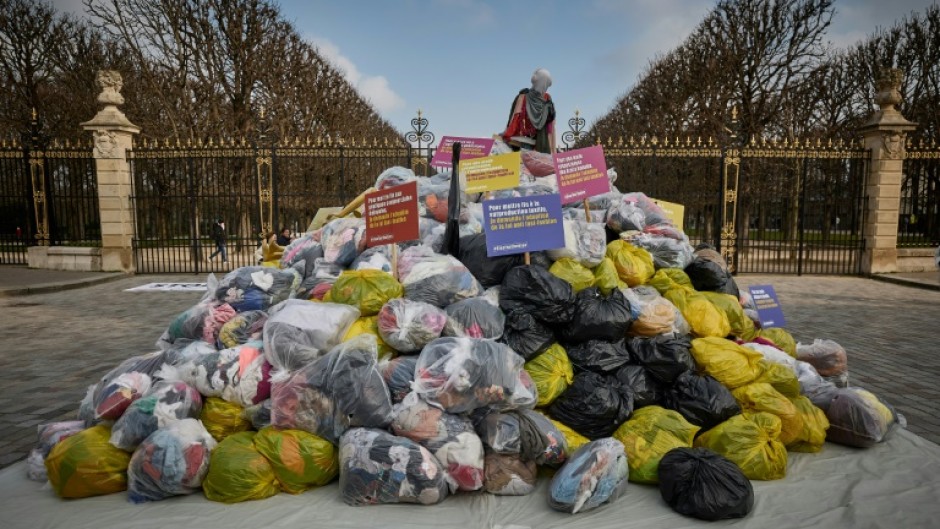 Dustbin bags full of clothes lie outside France's Senate in a March protest
