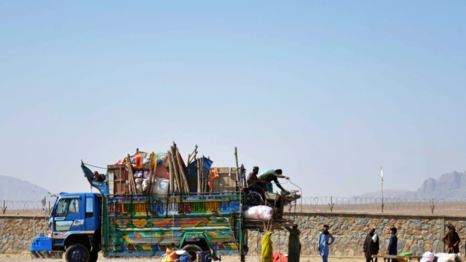Afghan refugees unload their belongings from a truck upon their arrival from Pakistan in May
