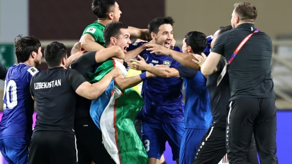 Uzbekistan's players celebrate after booking their berth in the FIFA World Cup for the first time with a draw against the United Arab Emirates in Abu Dhabi