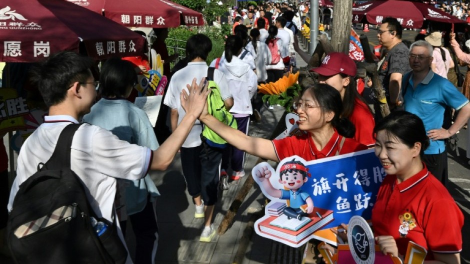 While teachers and staff offered students their support, holding up signs of encouragement, some test takers, dressed in school uniforms, appeared panicked
