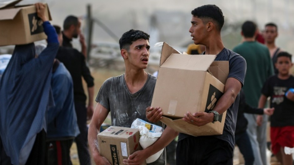 Palestinians carry food aid from the Gaza Humanitarian Foundation