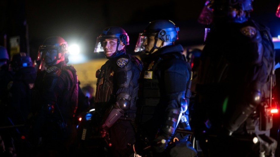 Law enforcement officers stand guard as they face off with demonstrators during a protest following federal immigration operations, in the Compton neighborhood of Los Angeles, California early on June 8, 2025