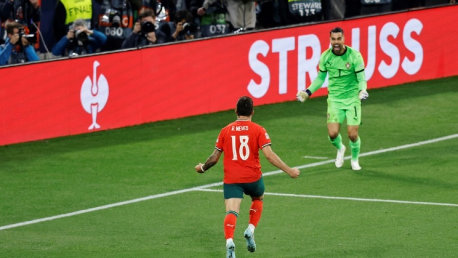 Ruben Neves runs toward Portugal's goalkeeper Diogo Costa after netting the winning penalty