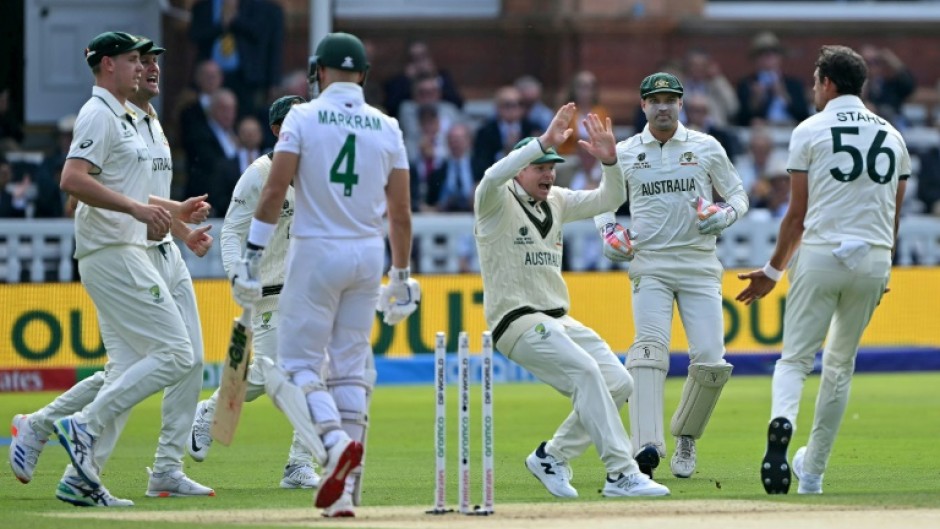 Australia's Mitchell Starc celebrates with Steve Smith (C) after dismissing South Africa's Aiden Markram