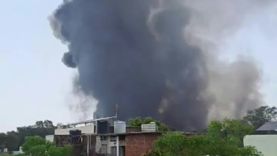 A huge plume of smoke rising from the crash site of the Air India plane