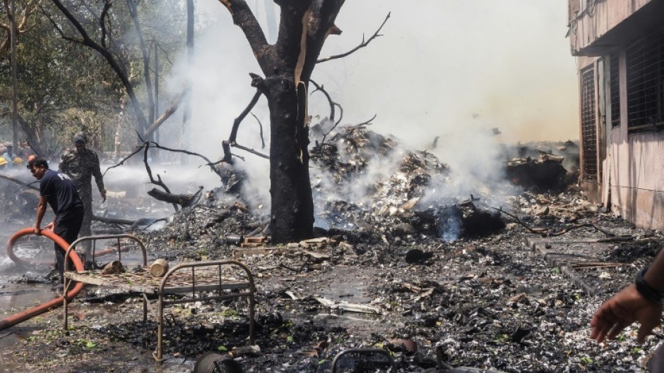 Firefighters work at the site where Air India flight 171 crashed