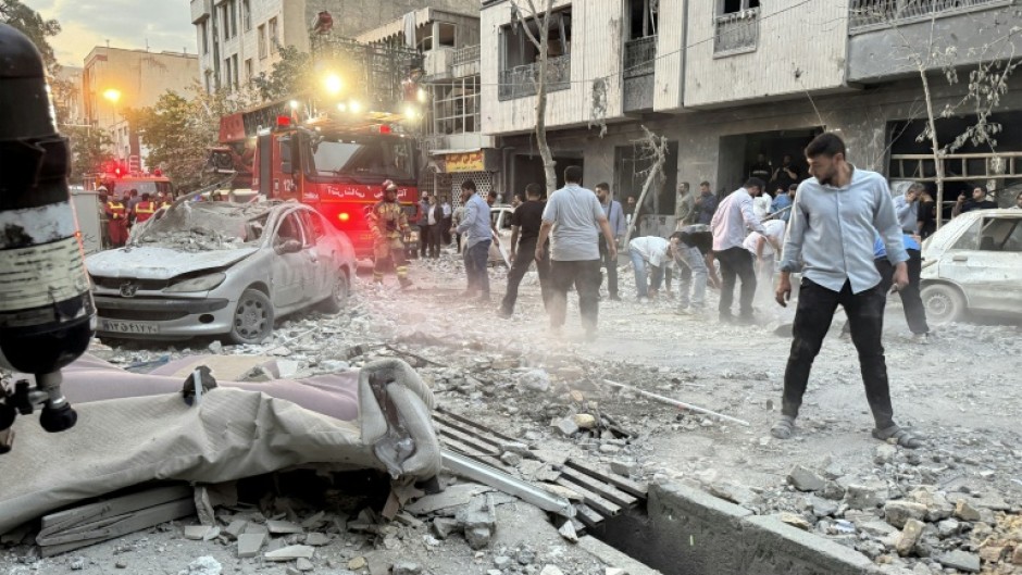 Iran's emergency services respond to an Israeli air strike which reduced much of a Tehran residential building to rubble.