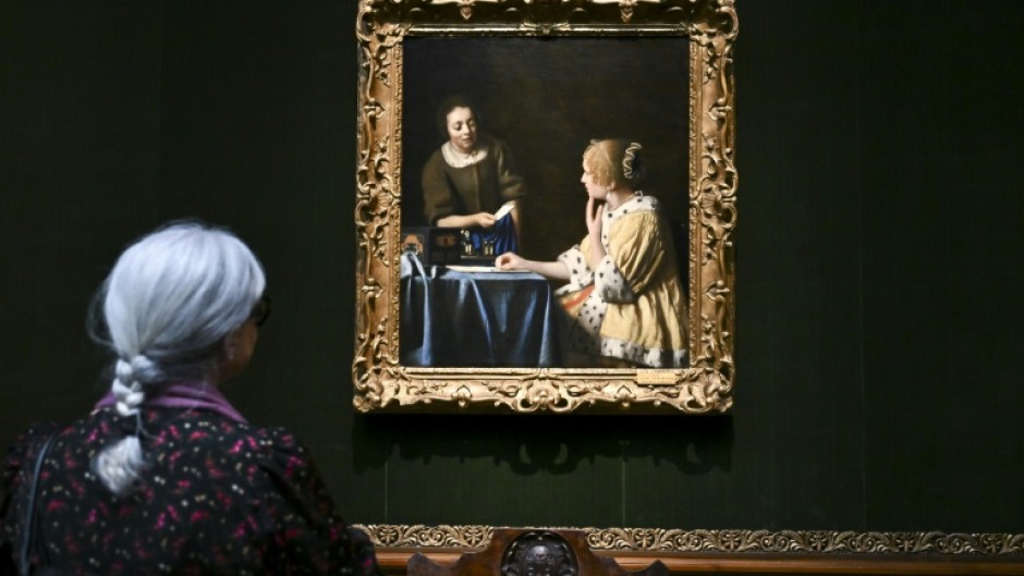 A woman views 'Mistress and Maid' by Johannes Vermeer at the Frick Collection in New York