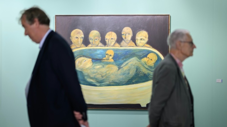 Visitors stand next to 'Die Wachter' by the Swiss artist Annette Barcelo at the Art Basel contemporary art fair