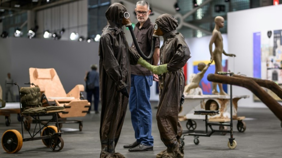 An Art Basel visitor has a close look at part of 'The Voyage -- A March To Utopia', by Atelier Van Lieshout