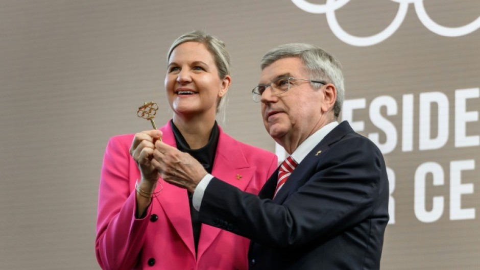 International Olympic Committee President Kirsty Coventry receives the ceremonial key from outgoing IOC President Thomas Bach during the handover ceremony