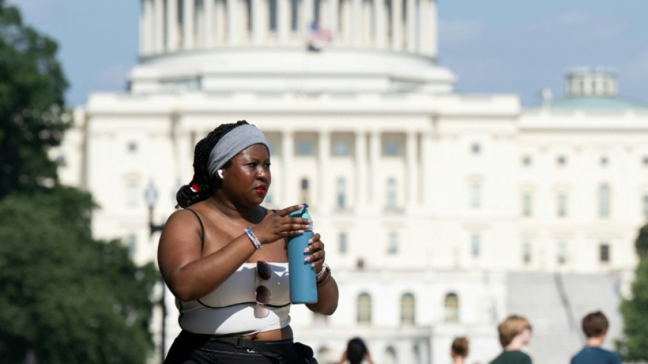 Extreme heat has scorched US cities like the capital Washington, where a woman on the National Mall is seen trying to stay comfortable in the summer weather