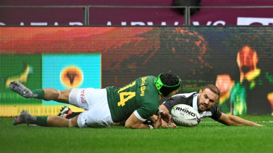 South Africa winger Cheslin Kolbe (L) scores against the Barbarians at Cape Town Stadium