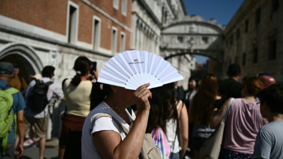 Tourists by the Bridge of Sighs in Venice walking in the heat