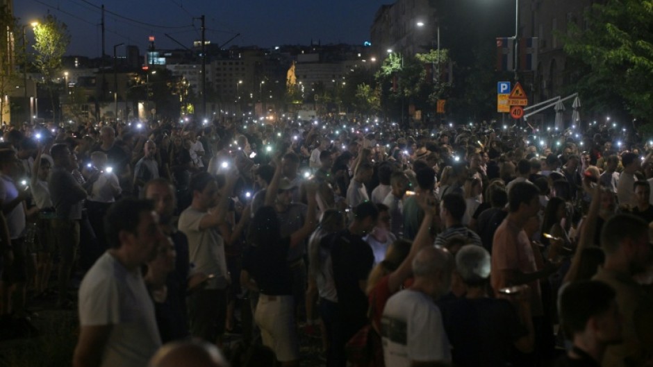 Protesters light up mobile phones as they demonstrate in front of the prosecutors offices calling for the release of their peers who were detained in protests the previous night