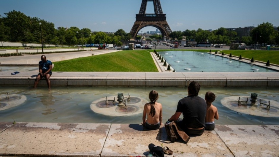Tourists cool off in the Trocadero Fountain in front of the Eiffel Tower