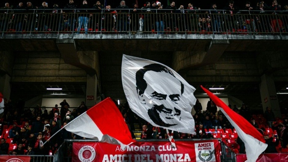 Monza fans wave a flag emblazoned with the image of flamboyant former owner Silvio Berlusconi