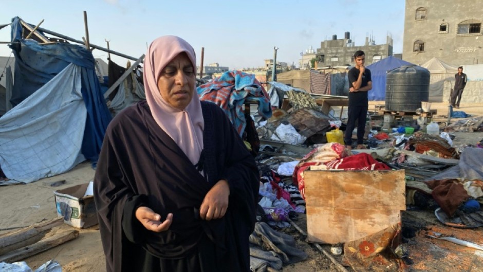 People inspect the damage after an Israeli strike on a camp housing displaced Palestinians in the southern Gaza Strip