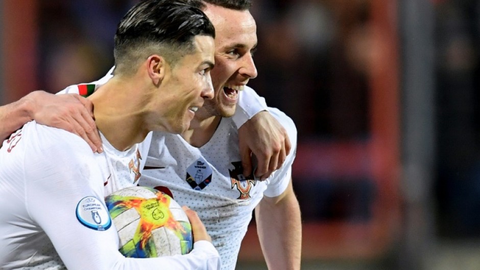 Cristiano Ronaldo (L) celebrates with Diogo Jota after scoring a goal in 2019