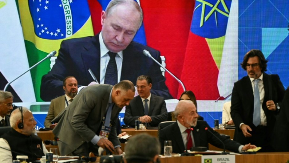 Russia's President Vladimir Putin is seen projected on a screen during the first plenary session of the BRICS summit in Rio de Janeiro, Brazil, on July 6, 2025.