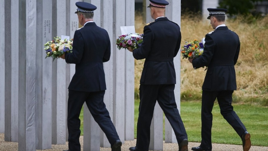 Police officers lay wreaths at the memorial to the July 7 victims in London's Hyde Park