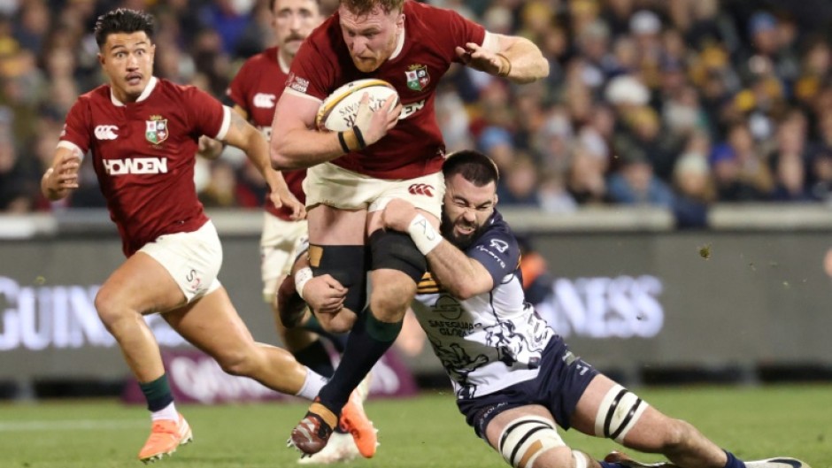 British and Irish Lions' Ollie Chessum (C) is tackled by ACT Brumbies' Luke Reimer