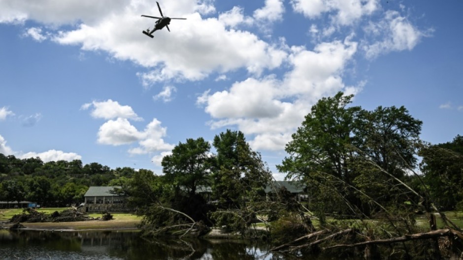 A search-and-rescue helicopter flies over Camp Mystic along the Guadalupe River in Hunt, Texas, where severe flash flooding over the Fourth of July holiday weekend left more than 120 people dead and another 170 missing