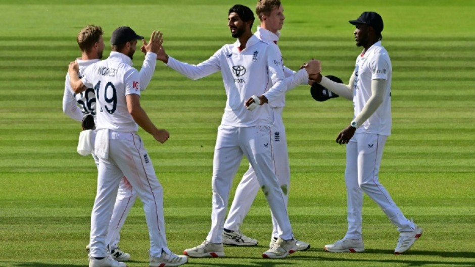 England's Shoaib Bashir (C) celebrates with team-mates Chris Woakes and Joe Root (L) after taking the clinching wicket in a 22-run win over India in the third Test at Lord's